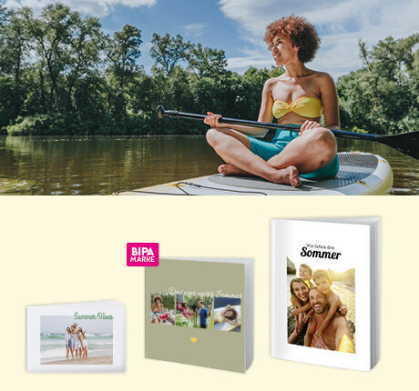 Junge Frau paddelt im Sommer auf einem See, links BIPA Fotobücher mit Urlaubsfotos und Sommerdesigns.