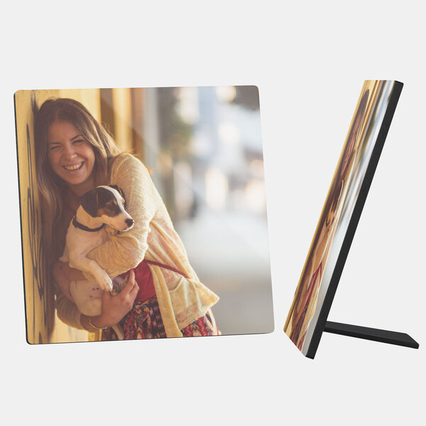 Ein quadratischer Fotoaufsteller zeigt ein fröhliches Bild von einer jungen Frau, die einen kleinen Hund im Arm hält.